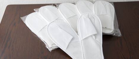 Un juego de pantuflas blancas sobre una mesa de madera.