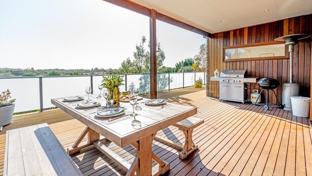 An outdoor deck with a wooden table set for dining, a grill, and a view of the water. - Highview - LOVE A ROOM WITH A VIEW (Tootgarook)