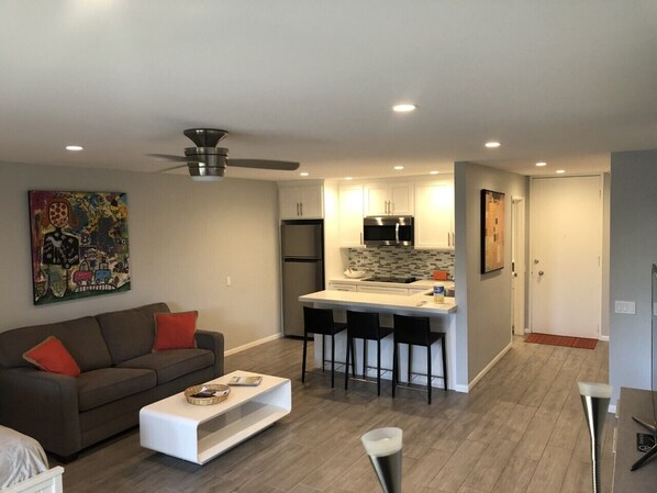 A modern apartment with a living room, kitchen, and dining area.