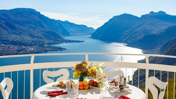 A table set for two with a view of a lake and mountains. - A Place That Stays With You - The Cloud House (bellagio)