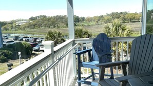 A covered outdoor area with a view of a parking lot and distant landscape. - Clean Beautifully Remodeled Beachfront Condo (Myrtle Beach)