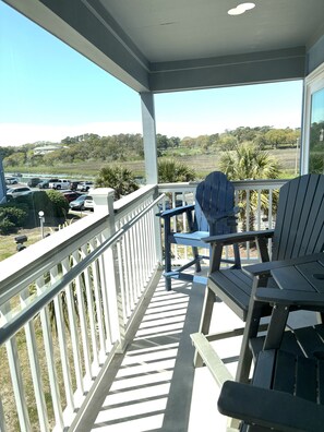 A covered outdoor area with a view of a parking lot and distant landscape.