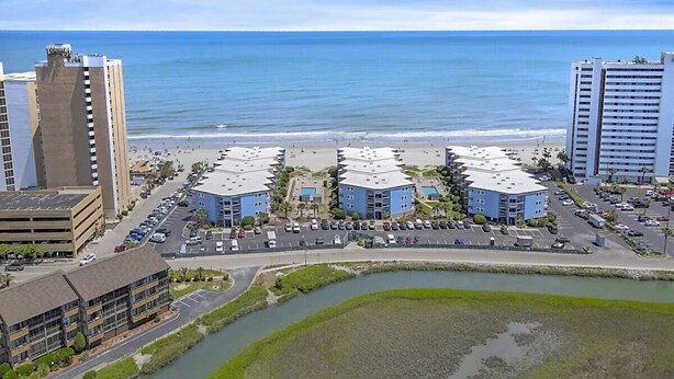 A coastal hotel with multiple buildings, a parking lot, and a beach view. - Clean Beautifully Remodeled Beachfront Condo (Myrtle Beach)