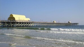 A pier with a large yellow dome structure extending into the water. - Clean Beautifully Remodeled Beachfront Condo (Myrtle Beach)