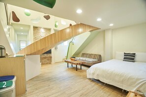 A modern room with a wooden staircase, a bed, a sofa, and a small table. - Happiness Yes Hostel Ⅲ (Luodong)