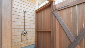 A wooden fence with a metal gate and a metal pipe attached to the wall. - Waterfront on Crystal Lake! (Orleans)