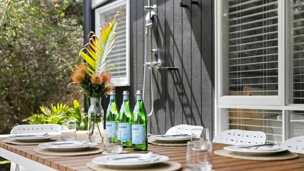 A table set for dining with plates, cutlery, and glasses, and three bottles of water labeled 'CRINO'.