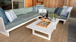 Uma sala de estar moderna com um sofá seccional, uma mesa de centro e um vaso de planta.