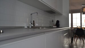 A modern kitchen with white cabinets, a stainless steel countertop, and a built-in oven. - NEVERENDING RIJANA, Cala Rijana at your fingertips! (calahonda)