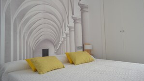 A bedroom with a white bed, two yellow pillows, and a white wall with a white arched ceiling design. - NEVERENDING RIJANA, Cala Rijana at your fingertips! (calahonda)