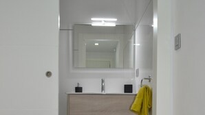 A bathroom with a white vanity, a mirror, a yellow towel, and a trash can. - NEVERENDING RIJANA, Cala Rijana at your fingertips! (calahonda)