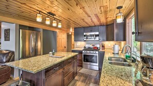 A modern kitchen with granite countertops, stainless steel appliances, and wooden ceiling. - Dock, Sauna & Hot Tub! 'Loon Lake Lodge' (Pequot Lakes)