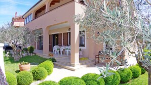 A two-story building with a covered patio, outdoor seating, and well-maintained landscaping. - Three bedroom apartment on the ground floor in the peaceful part of Pula (Pula)