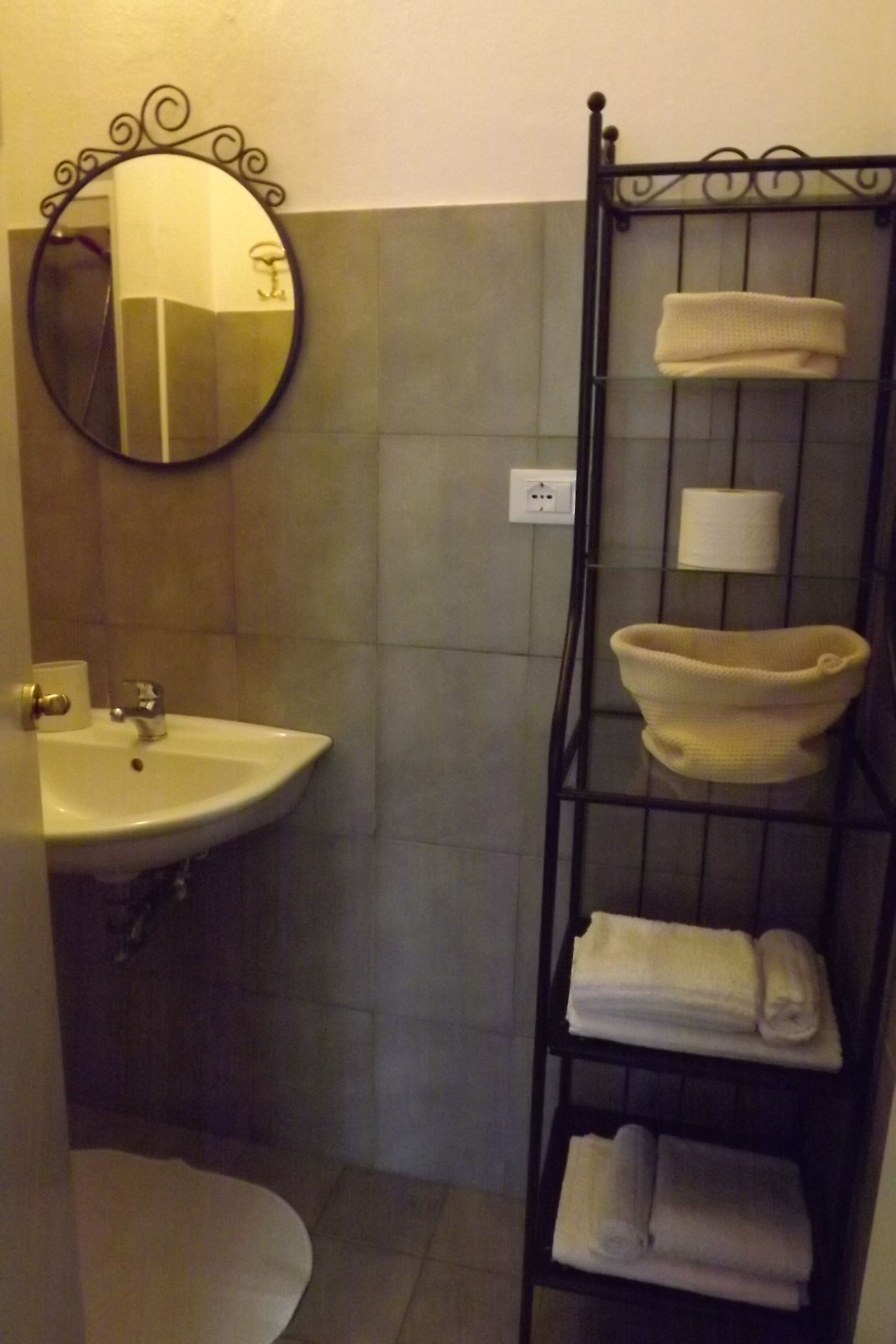 Een badkamer met een wastafel, spiegel en handdoekhouder.