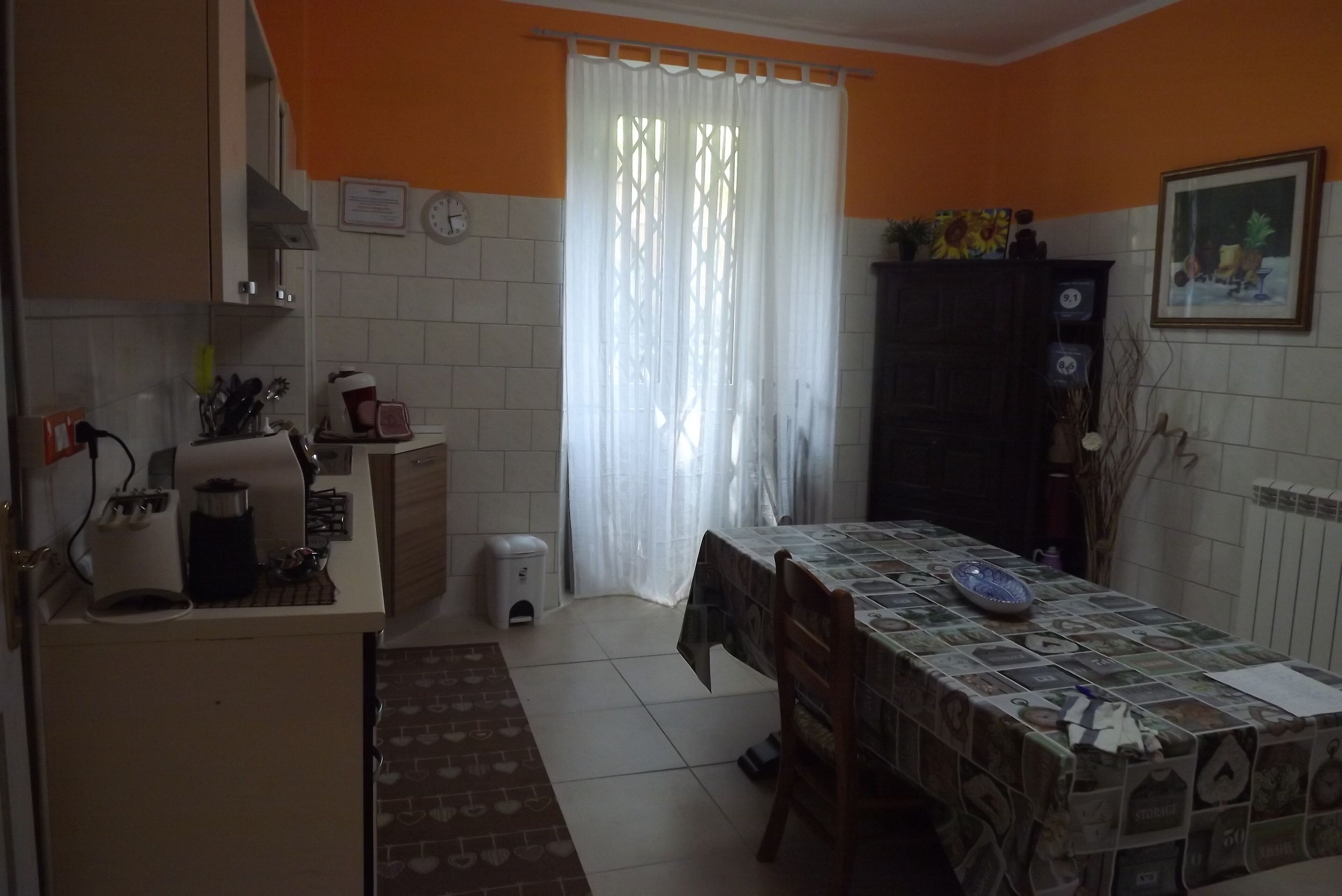 Una cucina con un tavolo apparecchiato per mangiare, una macchina per il caffè e un cestino.