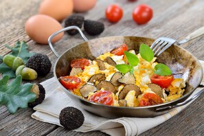 A skillet with scrambled eggs, tomatoes, and mushrooms. - Treehouse 2 people - spa & pool - exceptional view (Montréal-les-Sources)