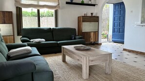 A living room with a green sofa, a wooden coffee table, and a patterned rug. - BEAUTIFUL HOUSE SEA VIEWS (Tossa de Mar)