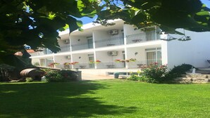 A building with a white facade, multiple balconies, and a well-maintained lawn. -  Rural accommodation Solar dos Marcos (Bemposta Mogadouro)