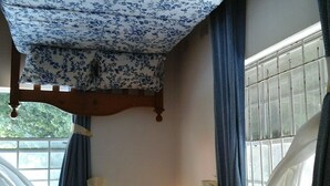 A room with a bed, a wall-mounted light, and a window with curtains. - very spacious, neat and organized (Gros Islet)