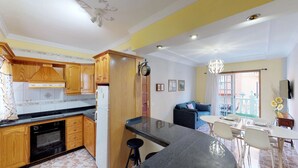 Una cucina moderna con mobili in legno, forno integrato e piano di lavoro nero.
