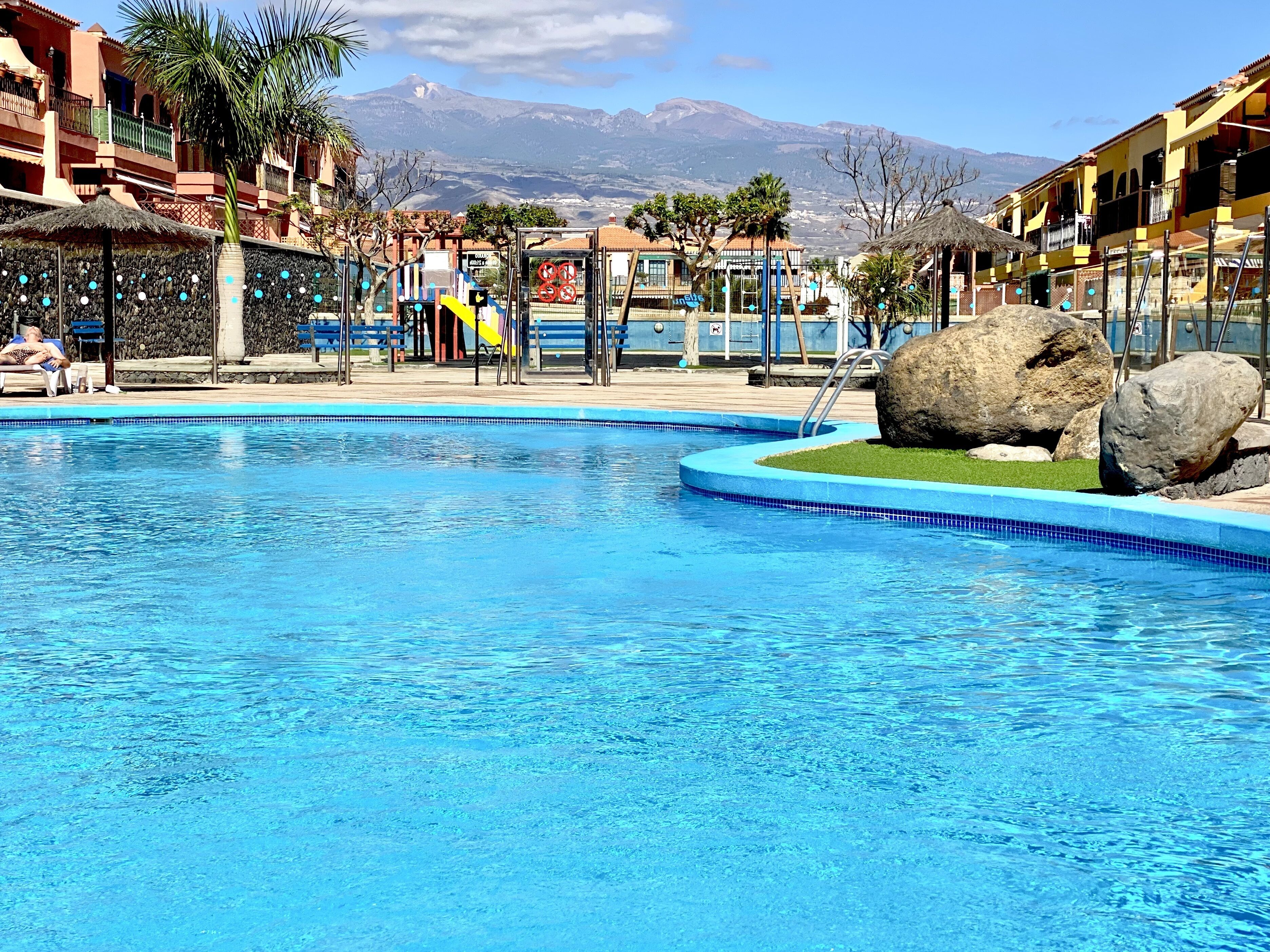 Una piscina con vistas a una cadena montañosa al fondo.