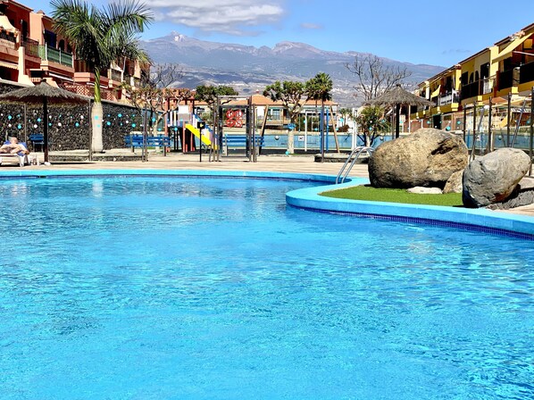 A swimming pool with a view of a mountain range in the background.
