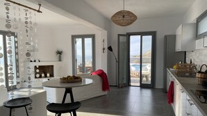 Una cocina moderna con una isla central, ventanas amplias y vistas al mar.