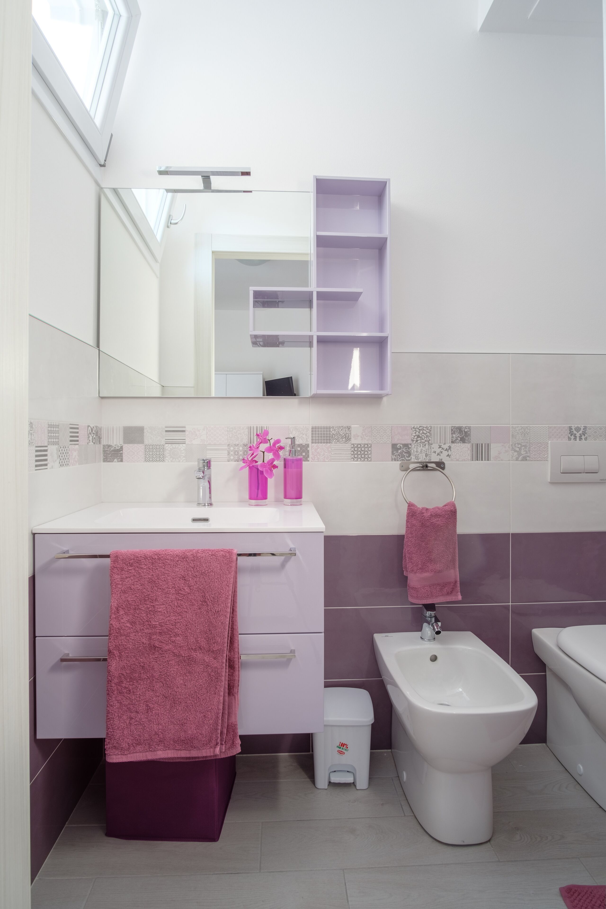 A modern bathroom with a vanity, bidet, and a mirror.