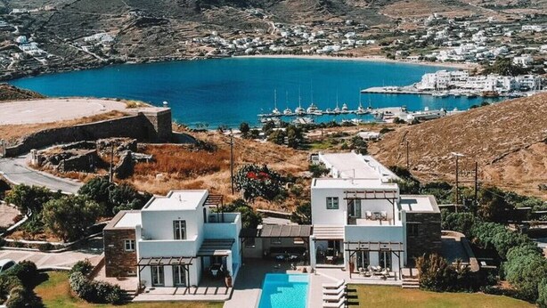A coastal property with a swimming pool, white buildings, and a view of the sea and mountains. - On The Rocks - The Two Rocks - Serviced Villa (Ios)