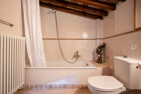 A bathroom with a bathtub, toilet, and radiator. - Fantastic family villa with pool.... (Barga)
