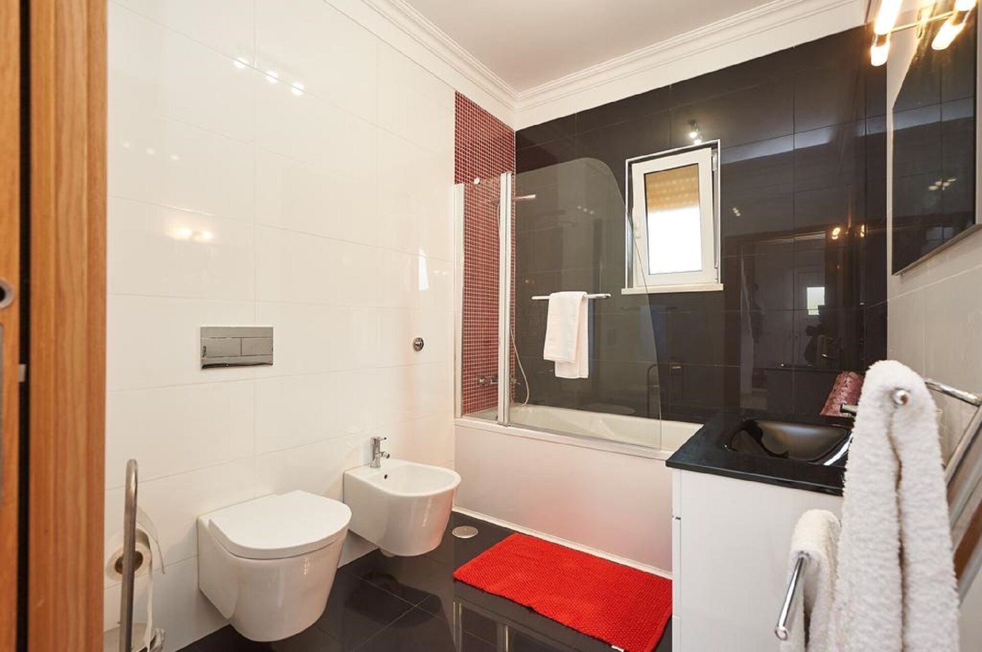 A modern bathroom with a toilet, bidet, and sink.