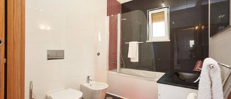 A modern bathroom with a toilet, bidet, and sink.