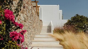 A stone staircase leading to a white building with a clear sky above.