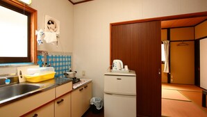 A compact kitchen with a sink, a small refrigerator, and a window. - Senju no sato Ramune Onsen (Kirishima)