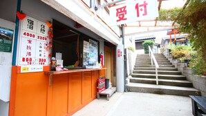 A hotel entrance with a sign indicating room availability and prices. - Senju no sato Ramune Onsen (Kirishima)