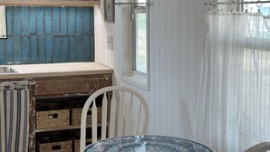 A kitchen with a blue wall, a wooden table, and white chairs. - Surfside Beach, Texas. Fantastic views of the beach and bay. Steps to the beach (Freeport)