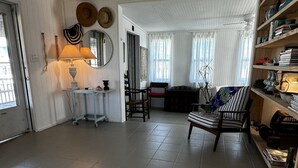 A spacious living room with a high ceiling, a sofa, a chair, and a bookshelf. - Surfside Beach, Texas. Fantastic views of the beach and bay. Steps to the beach (Freeport)