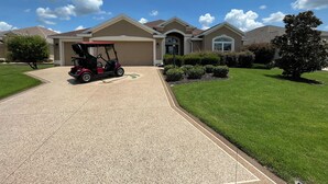 Une maison d’habitation avec une allée, un véhicule de golf et des pelouses bien entretenues.