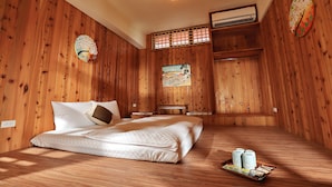 A wooden room with a bed, a small table, and a wall-mounted air conditioner. - Green Resort (Wujie)