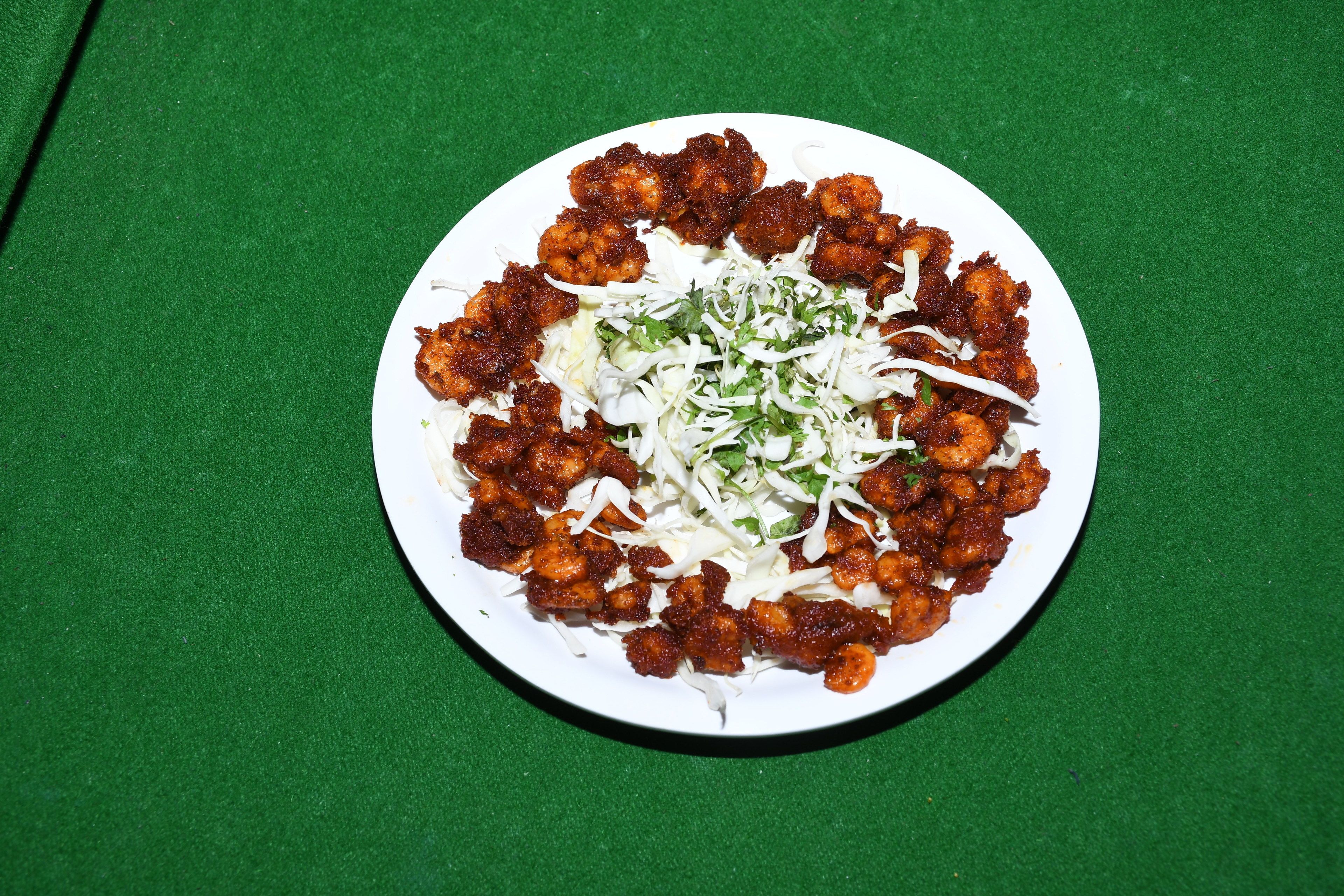 Ein Teller Essen mit gehobeltem Gemüse und einem grünen Hintergrund.