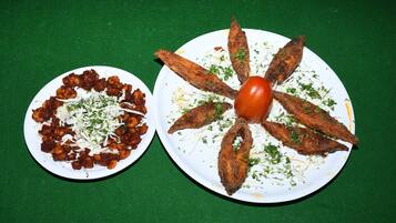 Two plates of food on a green tablecloth.