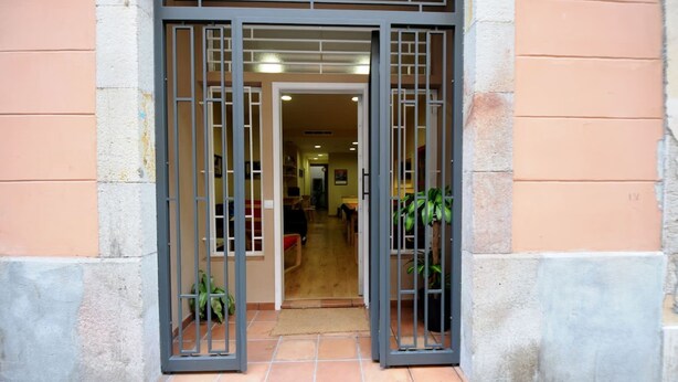 A doorway with metal gates, leading into a hallway with a carpeted floor and a visible sofa.