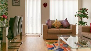 A living room with a sofa, two chairs, a coffee table, and a patterned rug.
