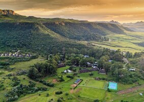 Vista aérea de una zona rural con casas, cancha de tenis y abundante vegetación.