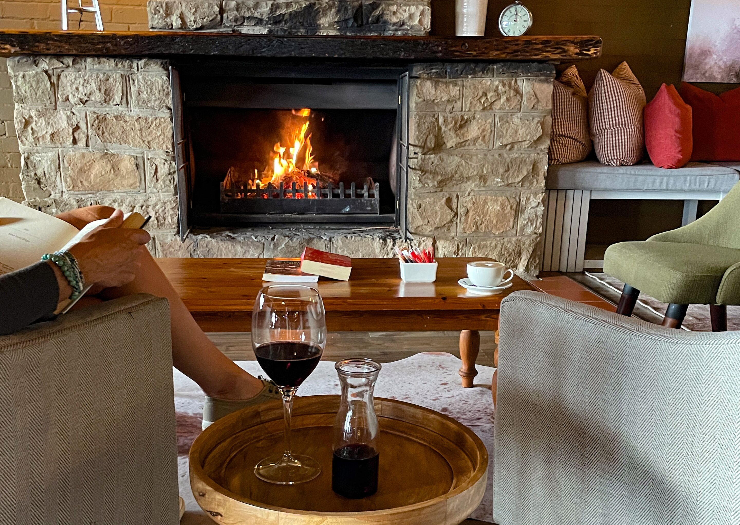 A cozy living room with a stone fireplace, a wooden coffee table, and comfortable seating.