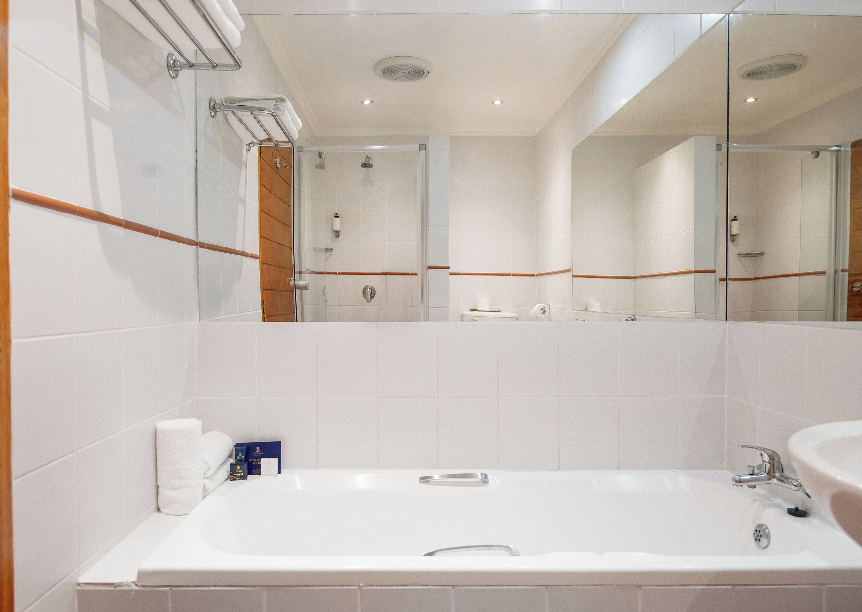 Een moderne badkamer met een ruime badkuip, een wastafel en een douche.