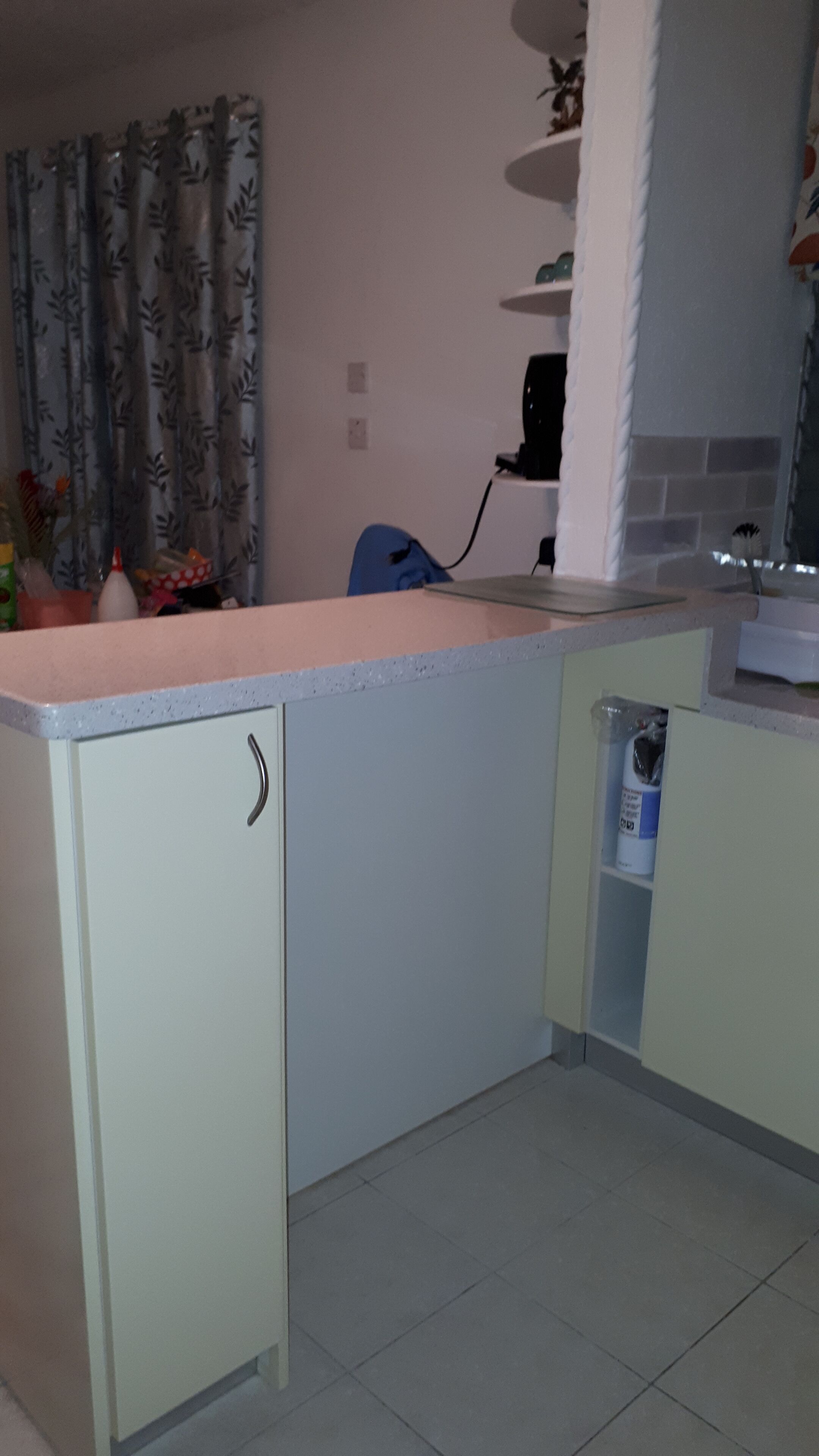 Una cocina con mostrador, armarios, un lavabo y un microondas.