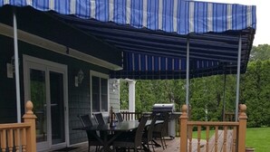 A wooden deck with a covered patio area, outdoor furniture, and a grill. - Beautiful Colonial Mint Condition Summer House Walking Distance to Beach (Laurel)