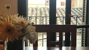 A wooden table with a vase of flowers in front of a window. - NICE APARTMENT in the CENTER of TOSSA (Tossa de Mar)