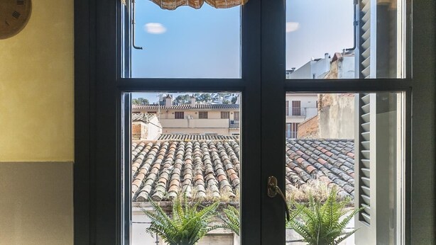 A door with a view of terracotta-tiled rooftops and a clock on the wall. - NICE APARTMENT in the CENTER of TOSSA (Tossa de Mar)